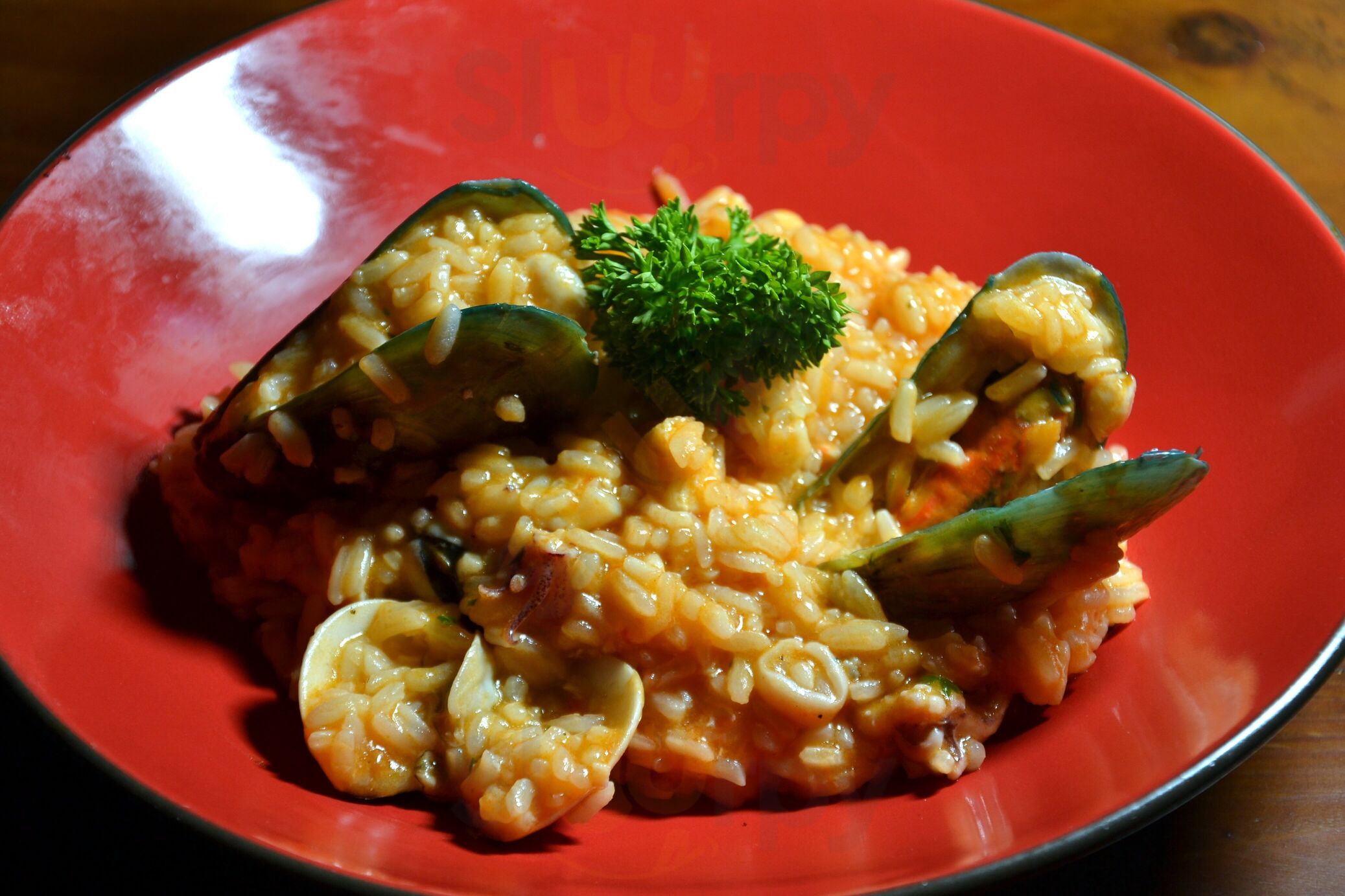 Seafood risotto in red bowl